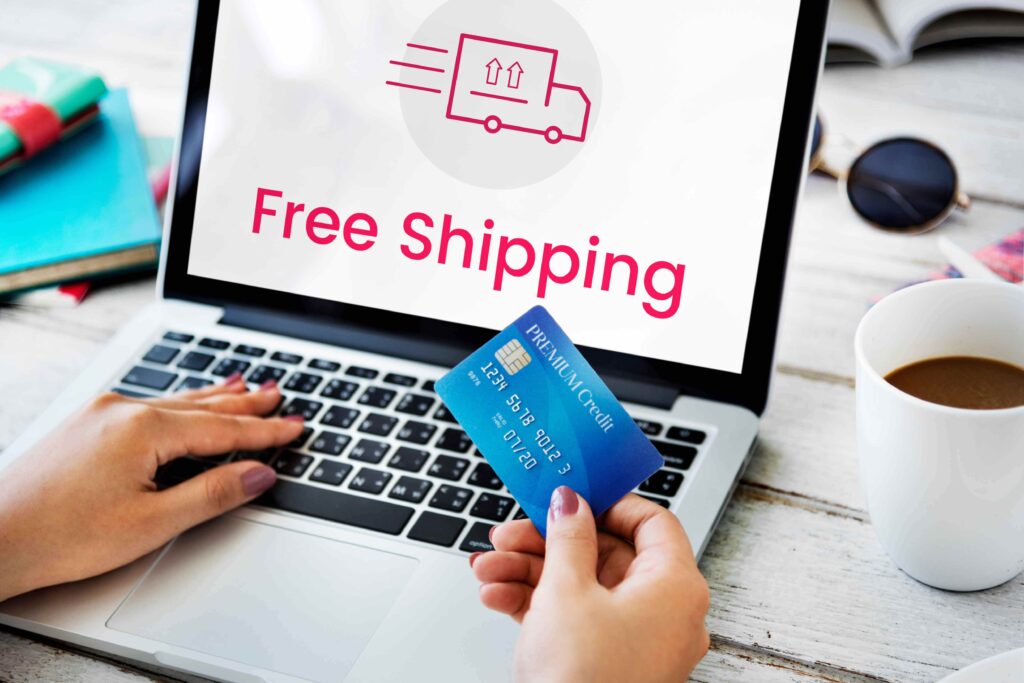 Person using a laptop with “Free Shipping” on screen while holding a credit card, representing the importance of affordable shipping in online shopping.